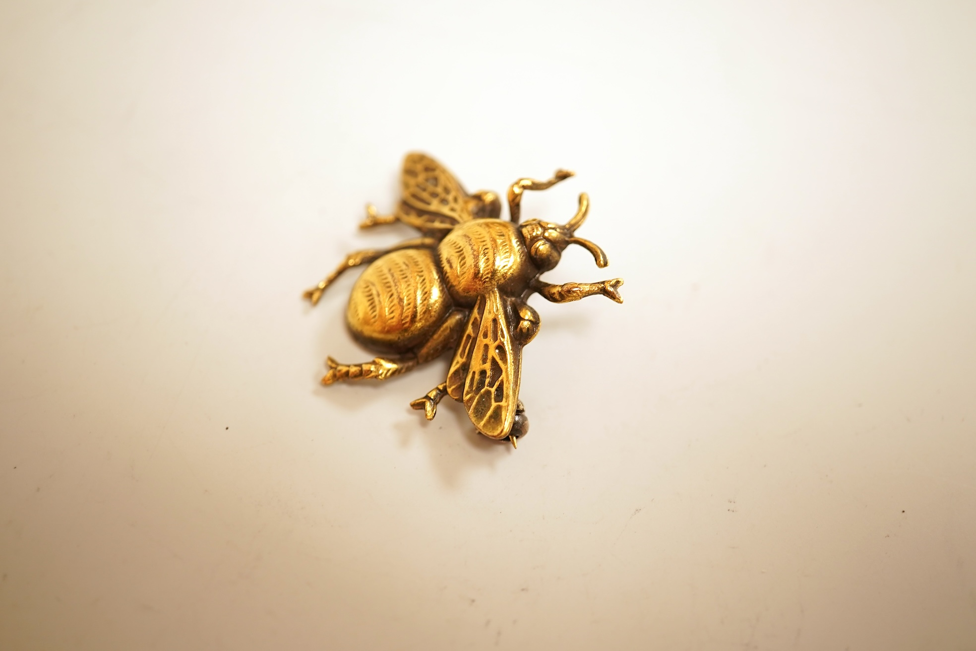 A mid 20th century North American gilt metal bee brooch by Joseff, wing span 30mm, together with a hard back copy of 'Jewelry of the Stars, Creations from Joseff of Hollywood' by Joanne Dubbs Ball.
